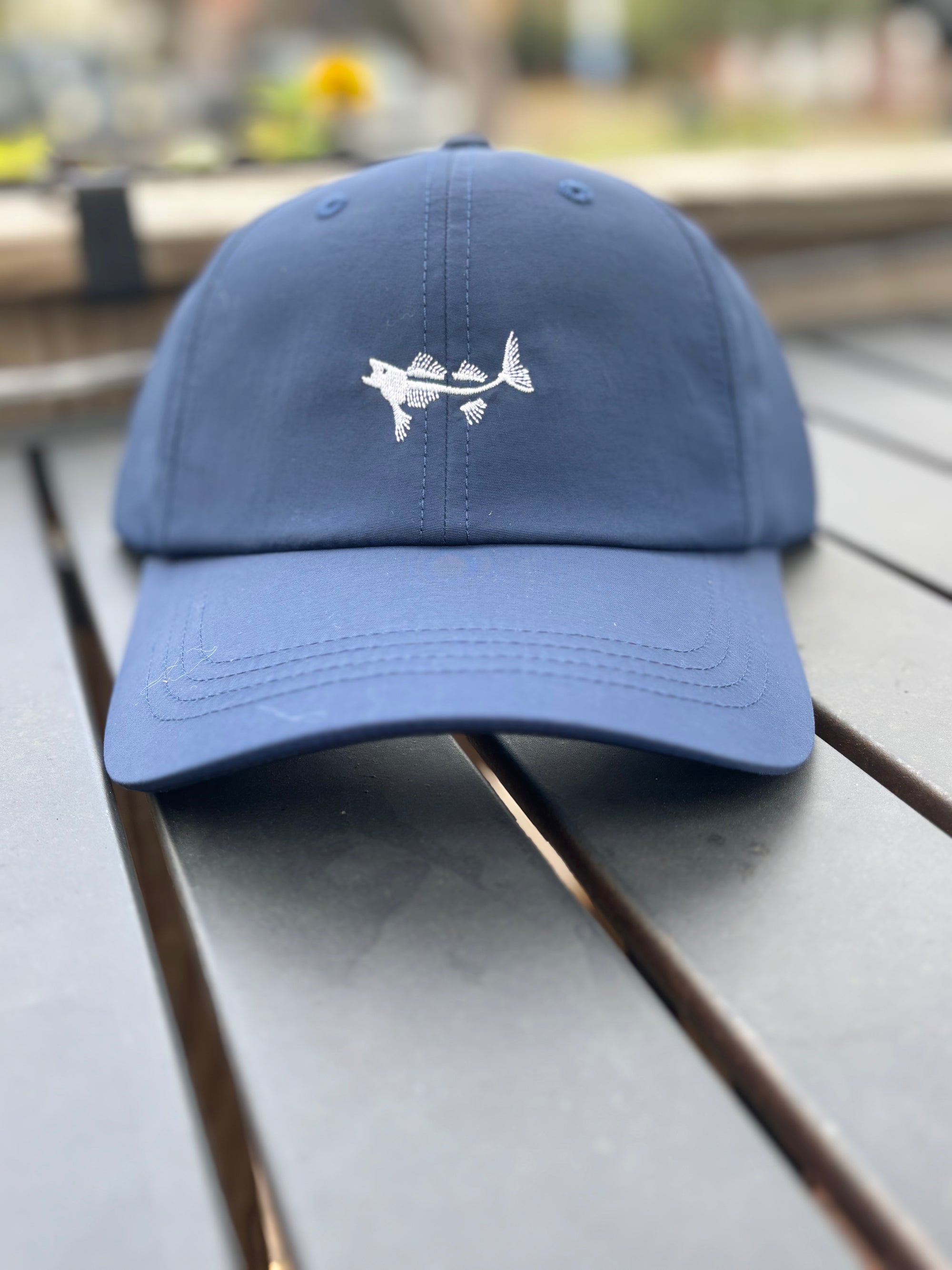 Coastal Cotton Trucker Hat in navy blue with a fish design for outdoor enthusiasts